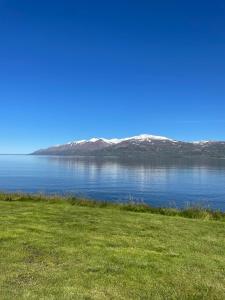 vista di una cassa d'acqua con montagne sullo sfondo di Ytri Vík a Hauganes