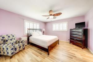 阿蘭薩斯港的住宿－Sea Grape，一间卧室配有一张床、一把椅子和吊扇