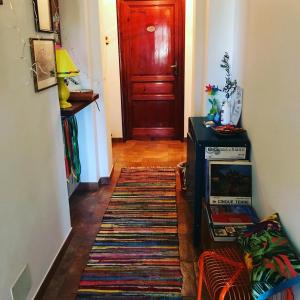 un pasillo con una puerta roja y una alfombra en Casa Tognetti en Migliarino