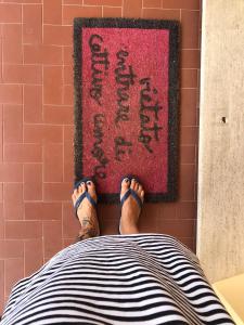 una persona acostada en una cama con sus pies en una alfombra en Casa Tognetti en Migliarino