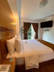 1 dormitorio con 1 cama blanca grande y ventana en 44 VIP Hotel, en Lima