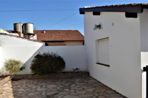 ein weißes Gebäude mit einer Tür und einem Fenster in der Unterkunft Casa Anne in Tandil