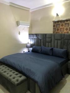 a bedroom with a large bed with a blue blanket at Well furnished and very spacious apartment in Wuye in Abuja