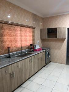 a kitchen with a sink and a washing machine at Well furnished and very spacious apartment in Wuye in Abuja