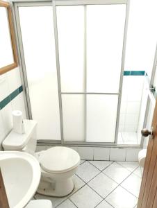 La salle de bains est pourvue de toilettes et d'un lavabo. dans l'établissement Hostal La Catolica, à Quito