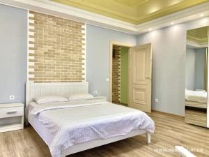 a bedroom with a bed and a brick wall at Аппартаменты в Центре in Poltava