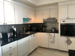 a kitchen with white cabinets and black counter tops at Penthouse Ocean Reserve in Miami Beach