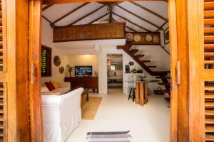 a living room with a white couch and a staircase at Bangalôs Meu Jardim Caraíva in Caraíva