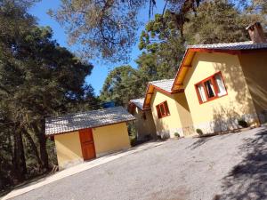 ein Haus mit einer Einfahrt davor in der Unterkunft Chalés Campo Verde in Camanducaia