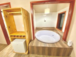 ein Bad mit einer großen Badewanne in einem Zimmer in der Unterkunft Chalés Campo Verde in Camanducaia