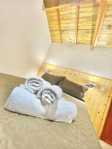 a pair of towels sitting on top of a bed at Chalés Campo Verde in Camanducaia