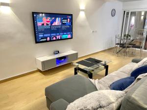 sala de estar con sofá y TV de pantalla plana en Modern Penthouse with Big Terrace, en Platja d'Aro