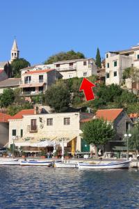 a group of boats on the water near a building at Apartments by the sea Povlja, Brac - 5644 in Povlja