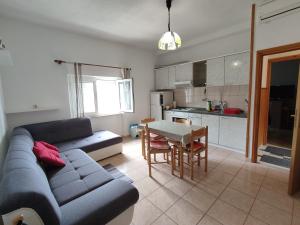 a living room with a couch and a table and a kitchen at Apartments by the sea Povlja, Brac - 5644 in Povlja