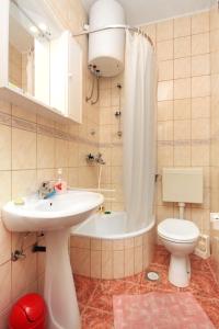 a bathroom with a sink and a toilet and a tub at Apartments by the sea Povlja, Brac - 5644 in Povlja