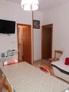 a living room with a table and a room with a bed at Apartments by the sea Povlja, Brac - 5644 in Povlja