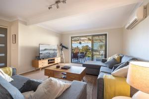 a living room with two couches and a tv at Casa Moana in Gerringong