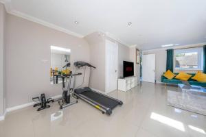 a room with a gym with a treadmill and a couch at Great Location Cheerful Entire Private 3 Bedroom 2 Bathroom House Sleeps up to 7 & Private Garden in London