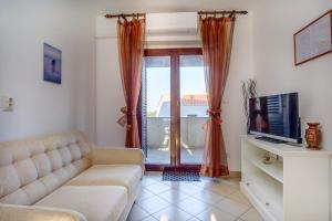 a living room with a couch and a tv at Apartments with a parking space Mali Losinj (Losinj) - 7879 in Mali Lošinj