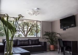 a living room with a couch and a tv at Hotel Parque Reservado in Pasto