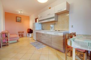 une cuisine et une salle à manger avec une table et une chambre dans l'établissement Apartment Mali Losinj 7879d, à Mali Lošinj