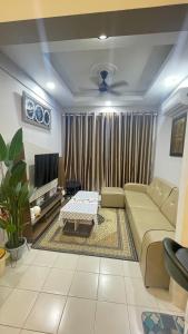 a living room with a couch and a tv at MAYEA Homestay in Sandakan