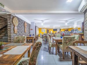 a restaurant with wooden tables and chairs at Alameda Paradiso Hotel in Gramado