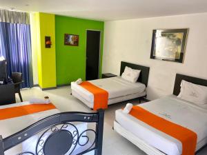 3 camas en una habitación con verde y blanco en Hotel Santelmo, en Cali
