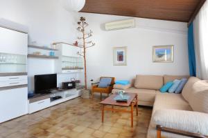 ein Wohnzimmer mit einem Sofa und einem Tisch in der Unterkunft Apartments by the sea Podgora, Makarska - 11432 in Podgora