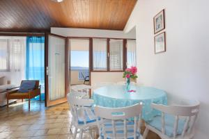 ein Esszimmer mit einem blauen Tisch und weißen Stühlen in der Unterkunft Apartments by the sea Podgora, Makarska - 11432 in Podgora