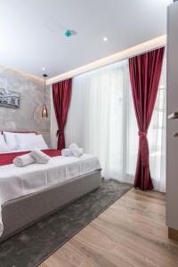 a bedroom with two beds and red curtains at Mayisa Apartments in Sarajevo