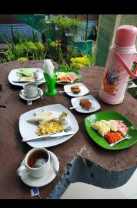 a table with plates of food and a cup of coffee at GumiBali Villa in Tirtagangga