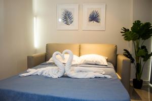 two white swans sitting on top of a bed at Apartamento en Sognare in Encarnación +18 photos