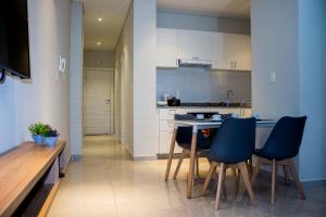 a kitchen with a table and blue chairs in it at Apartamento en Sognare in Encarnación