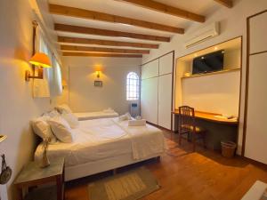 une chambre avec un lit et un bureau dans l'établissement La Maison Gerber, à Río Colorado