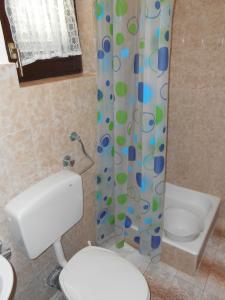 a bathroom with a toilet and a shower curtain at Apartments by the sea Cove Ostricka luka, Rogoznica - 11451 in Zaglavice