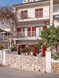 a house with red doors and a stone wall at Apartment Hvar 11427a in Hvar