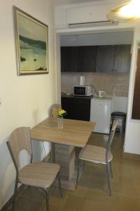 a kitchen with a wooden table and chairs in a room at Apartment Ostricka luka 11451b in Zaglavice