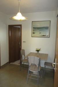 a dining room with a table and chairs and a light at Apartment Ostricka luka 11451b in Zaglavice +14 photos