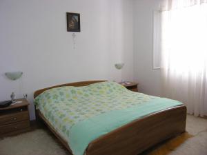 ein Bett in einem Schlafzimmer mit einem Fenster in der Unterkunft Apartments with WiFi Postira, Brac - 11494 in Postira