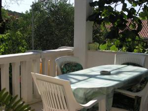 einen weißen Tisch und Stühle auf einem Balkon mit Tisch und Stühlen in der Unterkunft Apartments with WiFi Postira, Brac - 11494 in Postira