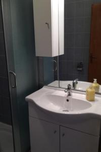 a bathroom with a white sink and a mirror at Studio Barbat 11472a in Rab