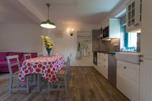 a kitchen with a table with a red and white table cloth at Holiday house with a parking space Kornic, Krk - 11504 in Kornić