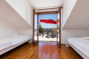 Pokój z 2 łóżkami i balkonem z otwartymi drzwiami w obiekcie Apartment Sumpetar 11462a w mieście Jesenice