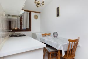 kuchnia ze stołem, krzesłami i kuchenką w obiekcie Apartments by the sea Sumpetar, Omis - 11462 w mieście Jesenice
