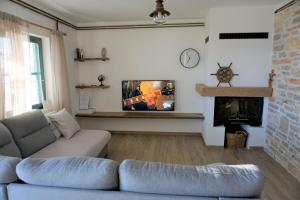 a living room with a couch and a fireplace at Secluded fisherman's cottage Cove Donje More, Pasman - 11515 in Tkon