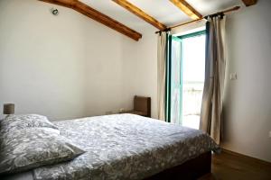 a bedroom with a bed and a large window at Secluded fisherman's cottage Cove Donje More, Pasman - 11515 in Tkon