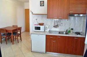 a small kitchen with a table and a microwave at Apartments with a parking space Selce, Crikvenica - 11527 in Selce