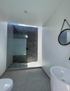 a bathroom with a shower and a toilet and a sink at Moringa Resort - Studio B with Pool, open Air Shared Shower Bath in Willemstad +27 photos