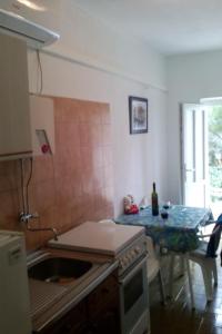 a kitchen with a sink and a table with a bottle of wine at Apartments by the sea Drvenik Donja vala, Makarska - 11553 in Drvenik